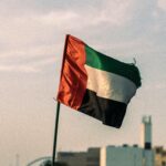 United Arab Emirates flag fluttering in a Dubai urban setting, captured during the day.